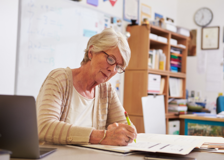 teacher grading homework at their desk
